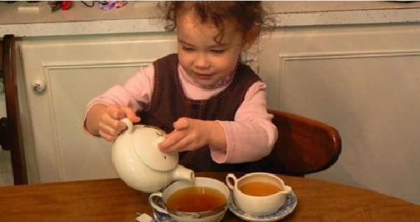 Ребенок наливает чай