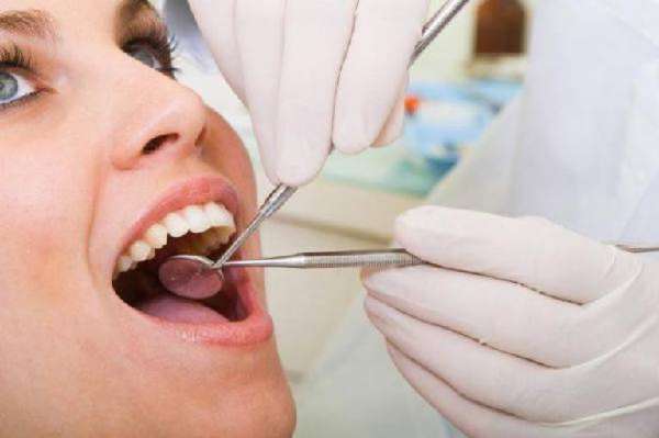 Стоматолог осматривает рот